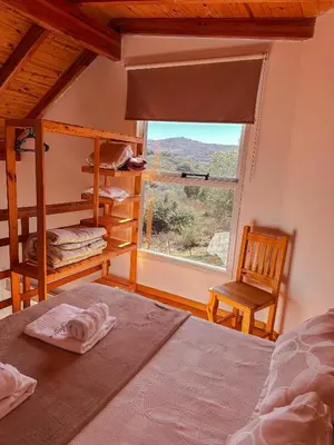 a bedroom with a bed and a window and a chair at El Refugio in Cordoba
