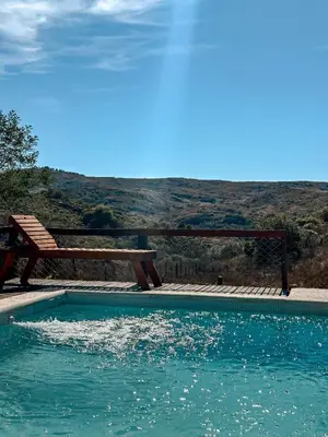 a bench sitting next to a swimming pool next to a bench at El Refugio in Cordoba