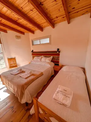 two beds in a room with wooden ceilings and wooden floors at El Refugio in Cordoba