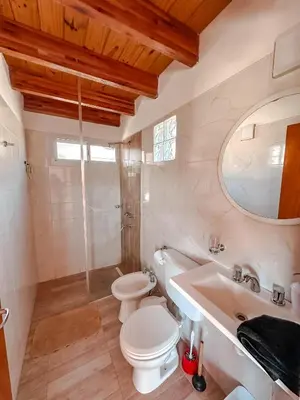 a white bathroom with a toilet and a sink at El Refugio in Cordoba