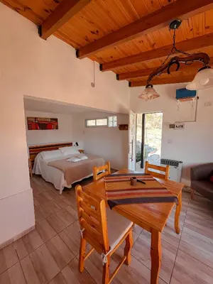 a bedroom with a bed and a table and chairs at El Refugio in Cordoba