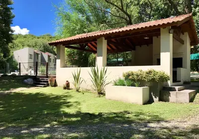 a small house with a dog sitting in the yard at Cabañas El Francés in Merlo