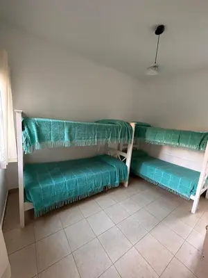 a room with two green benches in a room at Cabañas El Francés in Merlo