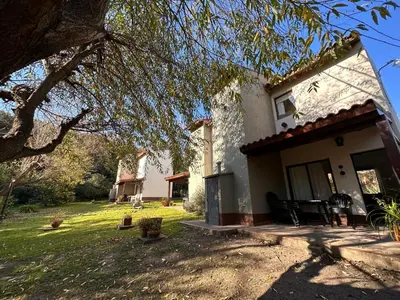 a white house with a porch and a yard at Cabañas El Francés in Merlo