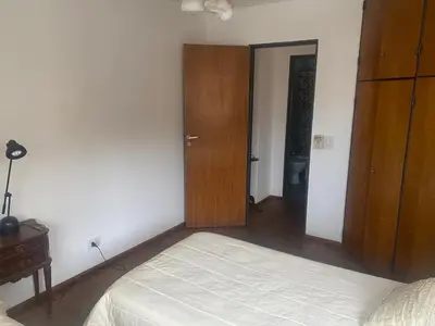 a bedroom with a bed and a wooden closet at Depto Boulevard Illia in Cordoba