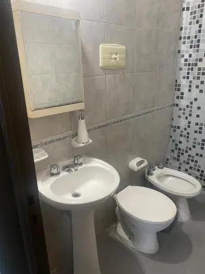 a bathroom with a sink and a toilet and a mirror at Depto Boulevard Illia in Cordoba