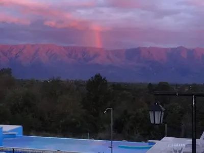 a rainbow in the sky with mountains in the background at Balcón de Nono in Nono