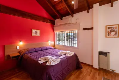 a bedroom with a purple bed with a red wall at Balcón de Nono in Nono