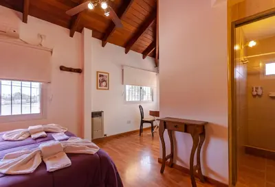 a bedroom with a bed and a wooden table at Balcón de Nono in Nono