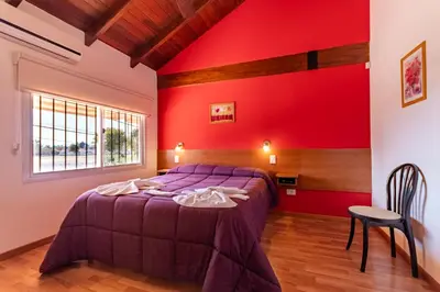 a bedroom with a purple bed and a red wall at Balcón de Nono in Nono