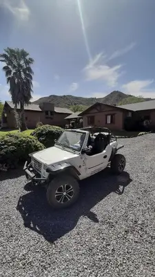 a white jeep parked in front of a house at Cabañas Ranger in Santa Rosa de Calamuchita