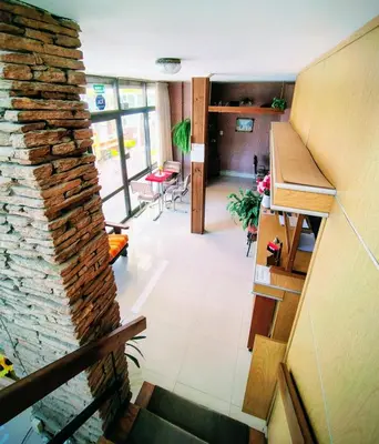 a living room with a stone wall and a staircase at Hotel Ritz in Villa Carlos Paz