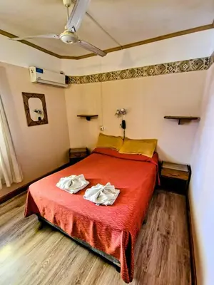 a bedroom with a red bed with two towels on it at Hotel Ritz in Villa Carlos Paz