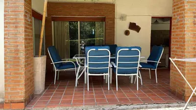 a table and chairs sitting on a patio at Casa con jardín, pileta, asador, y vistas al lago en Embalsina in Villa del Dique