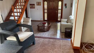 a living room with two chairs and a table at Casa con jardín, pileta, asador, y vistas al lago en Embalsina in Villa del Dique