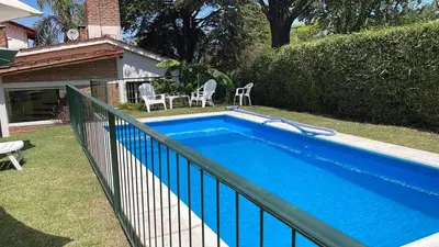 a swimming pool in a yard with a fence at Casa con jardín, pileta, asador, y vistas al lago en Embalsina in Villa del Dique