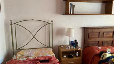a bedroom with a bed and a table with a lamp at Casa con jardín, pileta, asador, y vistas al lago en Embalsina in Villa del Dique