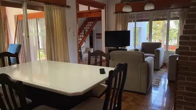 a living room with a large white table and chairs at Casa con jardín, pileta, asador, y vistas al lago en Embalsina in Villa del Dique