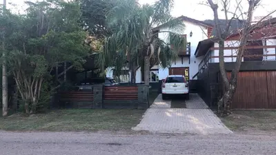 a white car parked in front of a house at Casa con jardín, pileta, asador, y vistas al lago en Embalsina in Villa del Dique