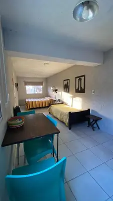 a bedroom with a bed and a table and chairs at Calamuchita Alquileres in Santa Rosa de Calamuchita
