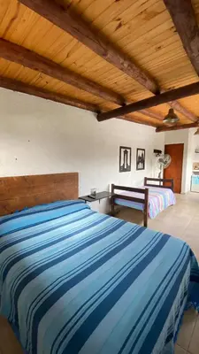 a bedroom with two beds and a wooden ceiling at Calamuchita Alquileres in Santa Rosa de Calamuchita
