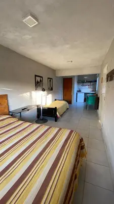a hotel room with two beds and a living room at Calamuchita Alquileres in Santa Rosa de Calamuchita