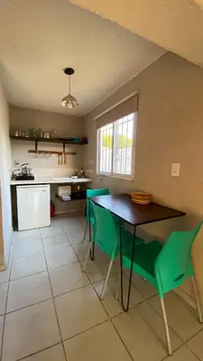 a kitchen with a table and green chairs at Calamuchita Alquileres in Santa Rosa de Calamuchita