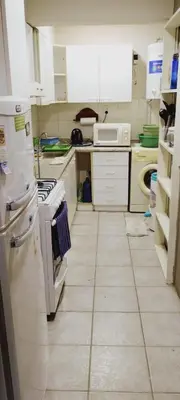a kitchen with white appliances and a tiled floor at Depto Plaza España in Cordoba