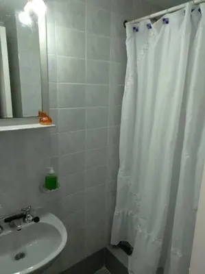 a bathroom with a shower curtain and a sink at Depto Plaza España in Cordoba