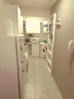 a white kitchen with a refrigerator and a microwave at Depto Plaza España in Cordoba