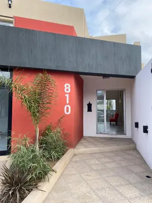 a red and white building with a red wall at Cañas Suites Villa Cura Brochero in Villa Cura Brochero