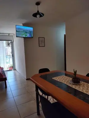 a dining room with a table and a television on the wall at Paraná Terrazas Nva Cordoba in Cordoba