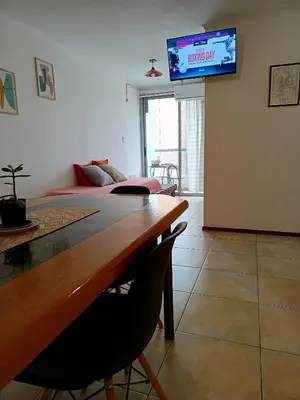 a living room with a table and a television on the wall at Paraná Terrazas Nva Cordoba in Cordoba
