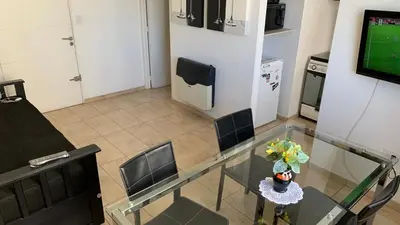 a glass table with a vase of flowers on it at Moderno Departamento Acogedor in Cordoba