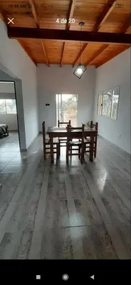 a large room with a wooden table and benches at La casita de Emilia in Los Molles