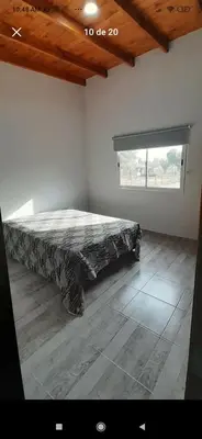 a bedroom with a bed in a room with a window at La casita de Emilia in Los Molles