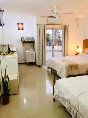a large bedroom with two beds and a window at Depto Av del Sol in Merlo
