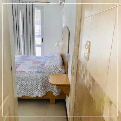 a small bedroom with a bed and a table at Depto Av del Sol in Merlo