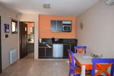 a kitchen with a table and chairs and a microwave at Moradillo Apart in La Cuesta