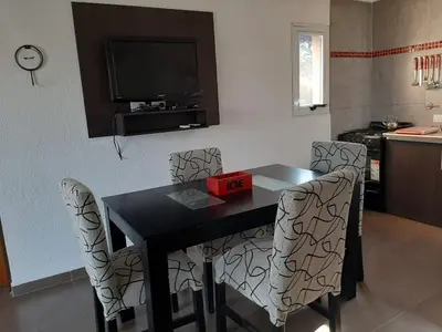 a dining room table with chairs and a television at Indigo CCH in Carpintería