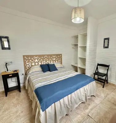 a bedroom with a large bed with blue pillows at ACOGEDOR Dpto Pasaje Tucumán in Alta Gracia