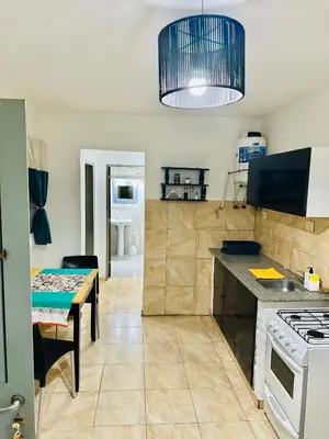 a kitchen with a table and a stove top oven at ACOGEDOR Dpto Pasaje Tucumán in Alta Gracia