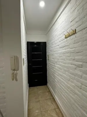a hallway with a black door and a phone at ACOGEDOR Dpto Pasaje Tucumán in Alta Gracia