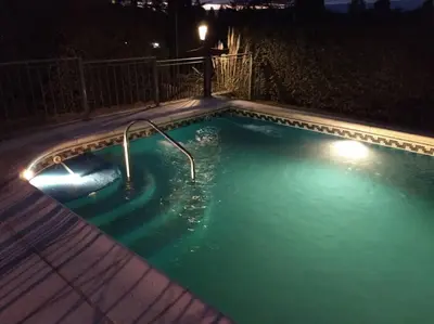 a swimming pool at night with a light in it at Unser traum in Villa General Belgrano