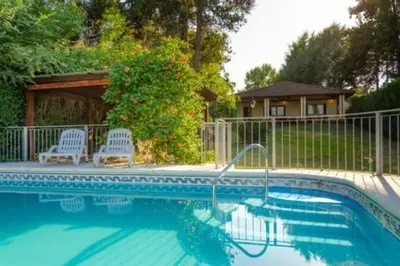 a swimming pool with two chairs and a gazebo at Unser traum in Villa General Belgrano