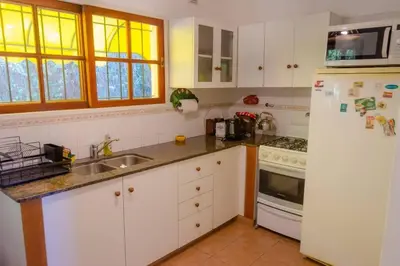 a kitchen with white cabinets and a white refrigerator at Unser traum in Villa General Belgrano