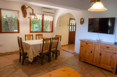 a dining room with a table and chairs and a tv at Unser traum in Villa General Belgrano