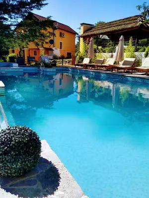 a swimming pool with chairs and umbrellas next to it at LAS PRINCESAS Cabañas frente al rio in Los Reartes