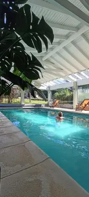 a person is swimming in a swimming pool at Samai Suma Cabañas & Spa in Villa General Belgrano
