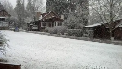 a yard covered in snow with a house at Samai Suma Cabañas & Spa in Villa General Belgrano